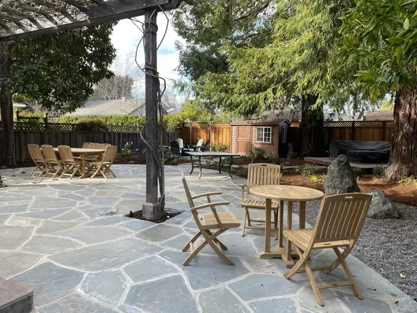 Flagstone patio with teak chairs under a pergola