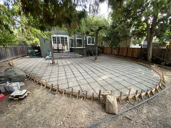 Before: forms and base laid out for a round patio in a backyard