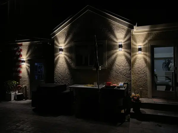 Exterior wall lights glowing on a home at night