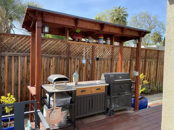 Wooden pavilion sheltering an outdoor kitchen and grill