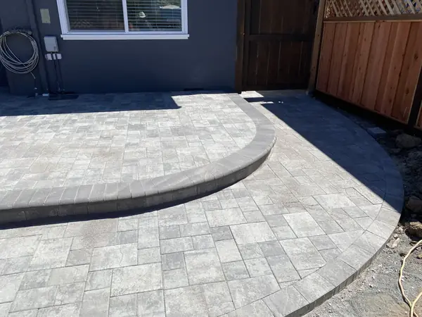 Gray paver patio with a curved step