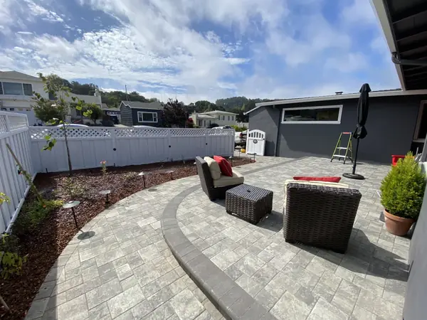 Gray paver patio with a curved step and outdoor seating