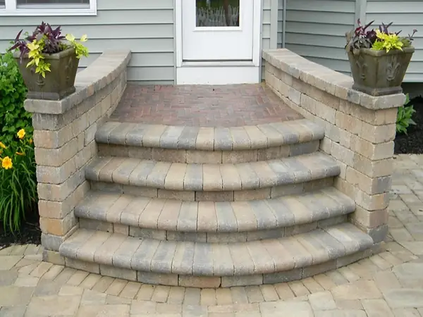 Curved paver steps framed by low seat walls and planters