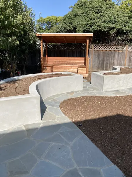 Curved concrete seat walls along a flagstone path